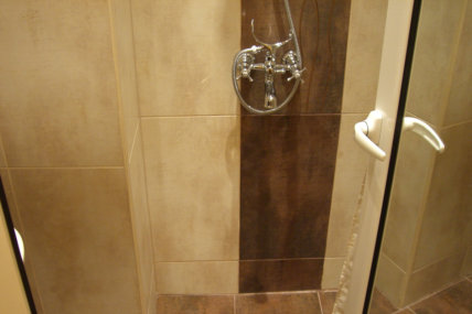 Баня с флорални мотиви на плочките и отлична душ система