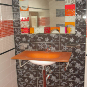 Оранжева мивка и стена с плочки на мотиви цветя